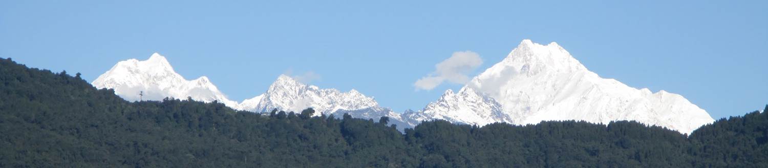 Mountains and trees in front of a blue sky image