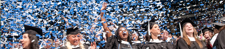 Students at a graduation ceremony surrounded by confetti