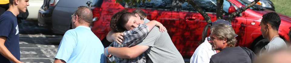 Two people hugging in a crowd of people