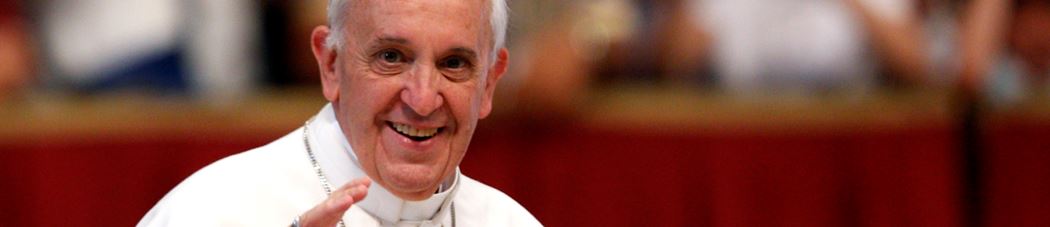 Pope Francis smiling and raising his hand