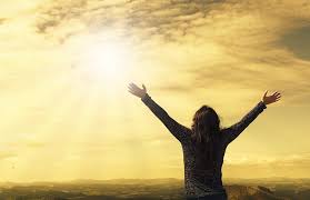 A person holding their arms up and out to the sun