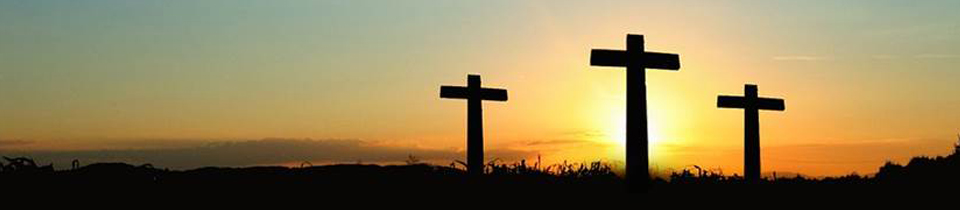 Photo of three large crosses in front of the sunrise