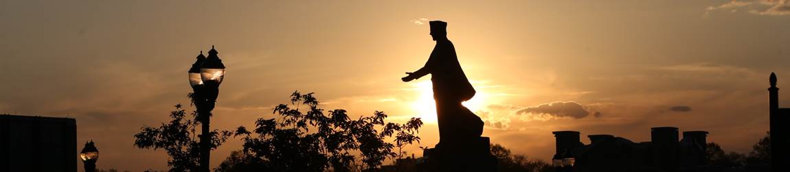 Photo of an outline of the St. Francis Xavier statue in front of a sunset 