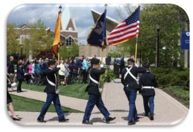 Soldiers parading outside with a flag