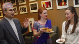 Three people holding food and talking