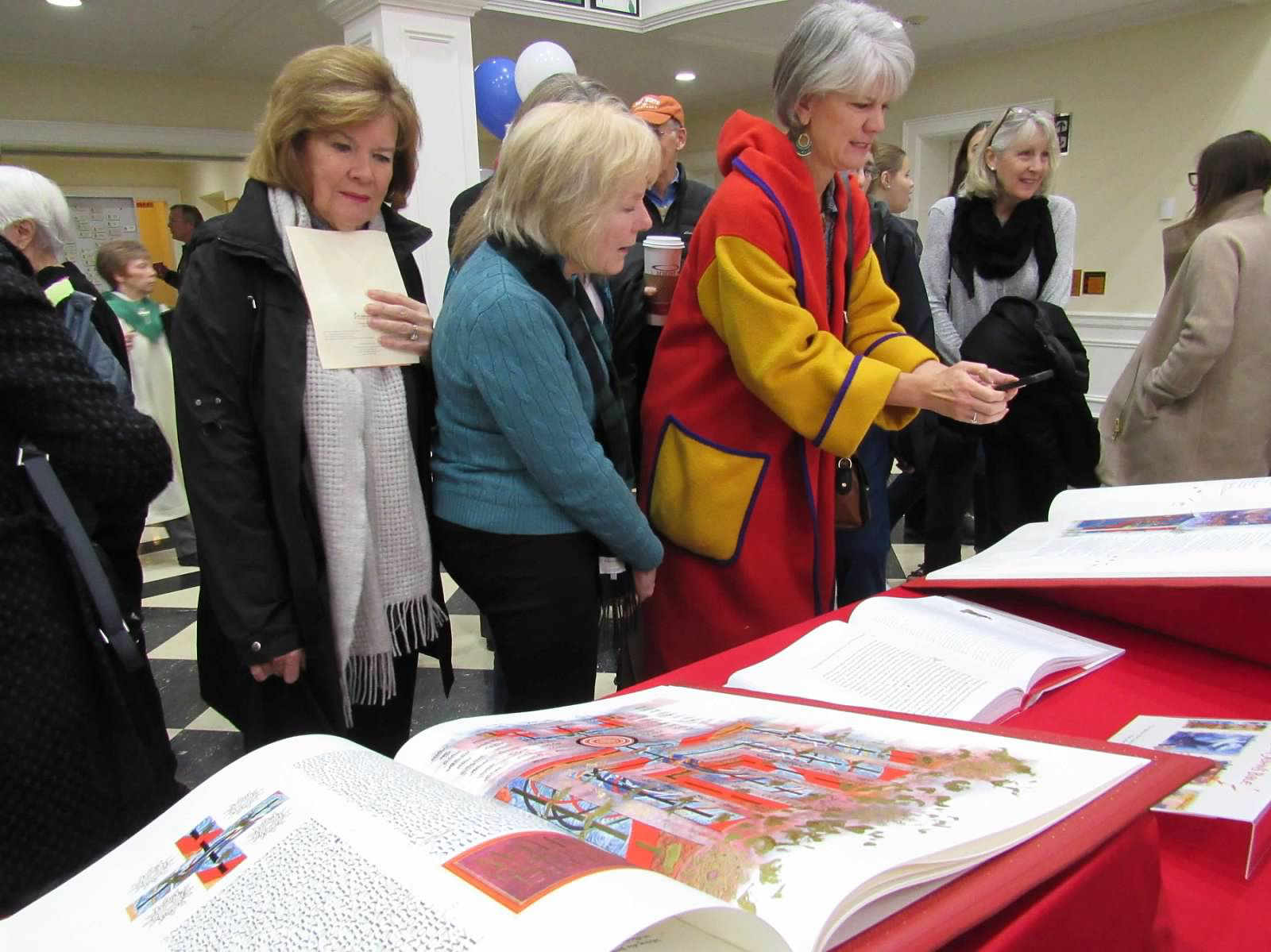 Parishioners view Saint Johns Bible in lobby of Mt. Washington Presbyterian Church