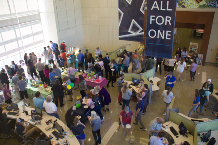 Over 100 people in CLC atrium viewing displays