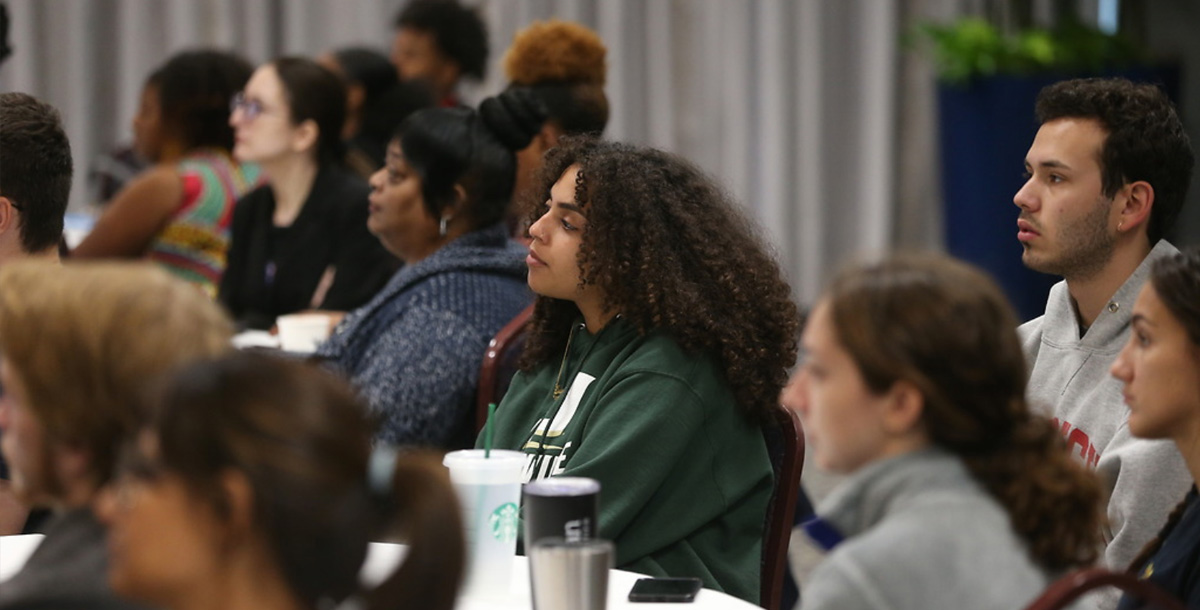 A group of students listening to a speaker during an information session