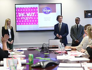 Students in the part-time MBA program pitching an idea to a company in a board room