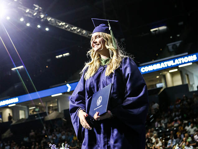 Photo of a student graduating with a EMBA