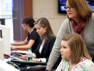 Students who are earning their secondary education master's degree are working on a computer 