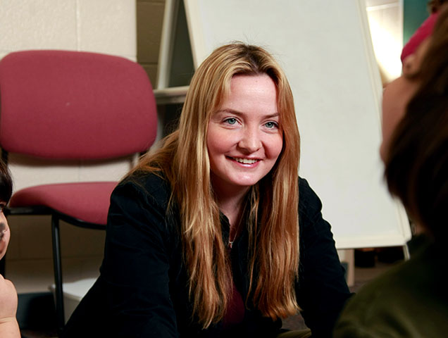 Student earning their Master of Health Services Administration degree connecting with a student in a classroom