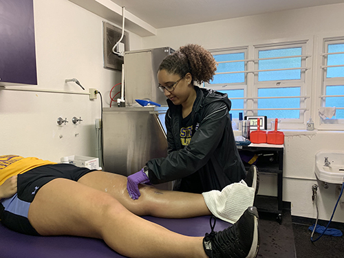 Photo of Madeleine Johnson helping an cured SFSU player