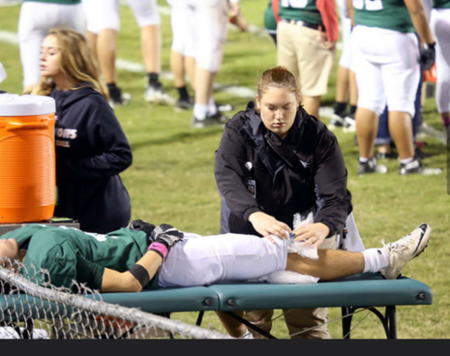 Photo of Colleen Earley helping an injured Athlete