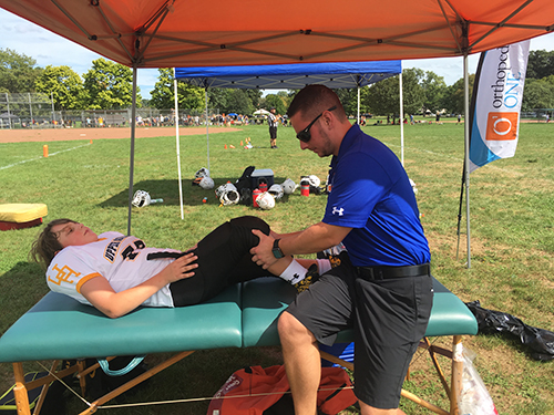Photo of Adam Battiato helping an injured Athlete