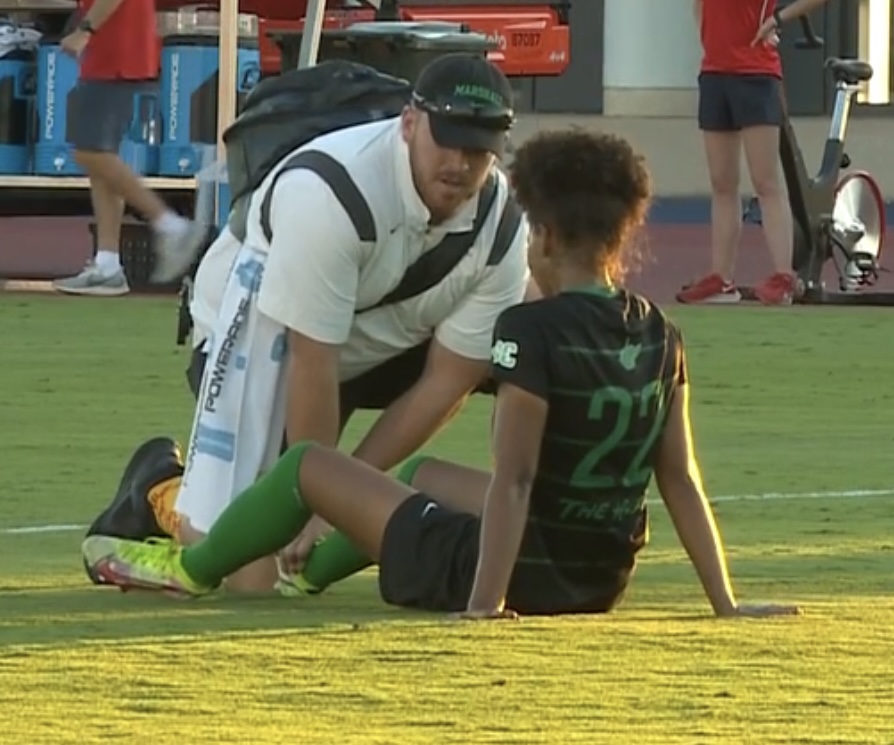Photo of Haden Maloney helping a Soccer Player