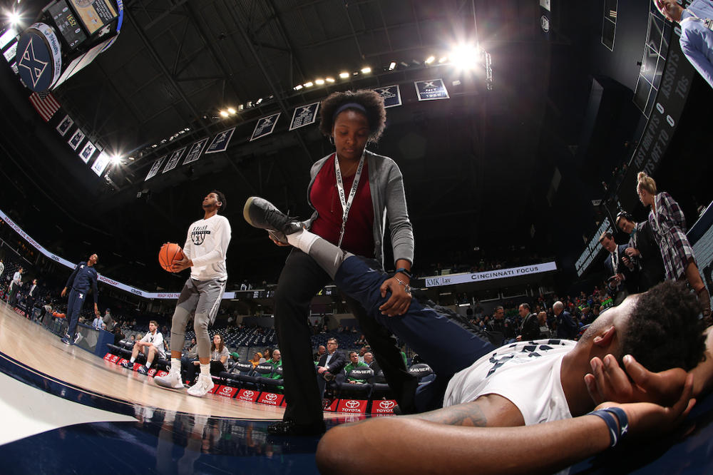 Xavier student stretching our athletes before a game.