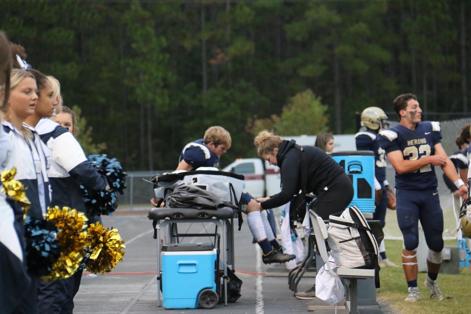 Photo of Mollie Borcherding helping an athlete out on a football field