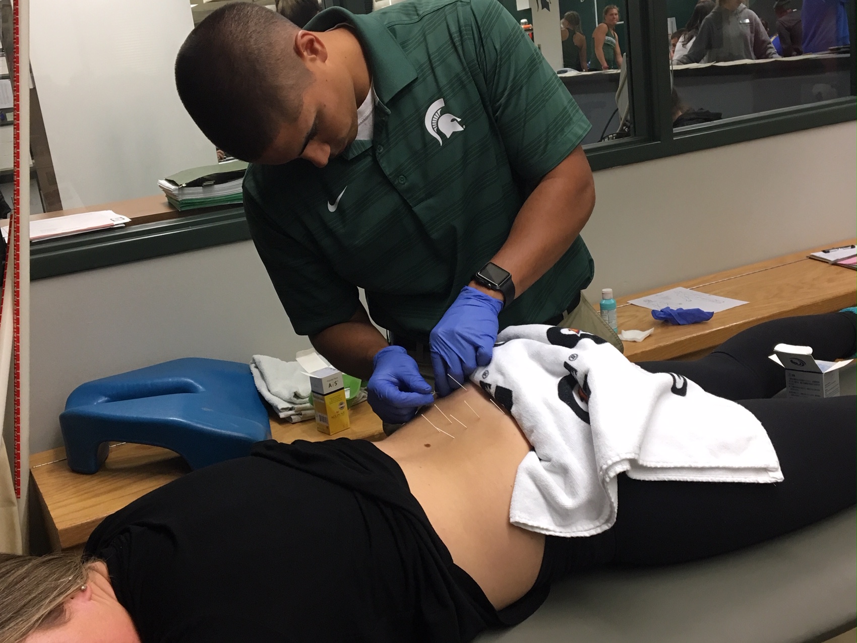 Photo of Vince Del Valle helping an injured Athlete