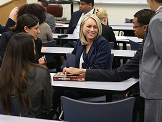 A group of students wearing business professional attire while sitting in a classroom