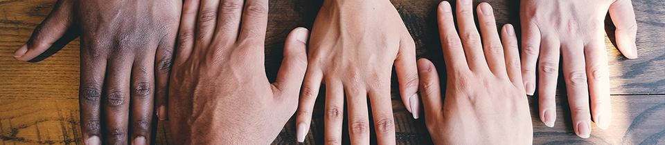 Photo of five hands of people of different races together in a line