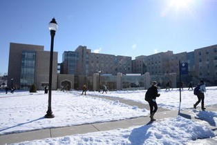 Picture of XU students in the snow with Fenwick lawn in the background