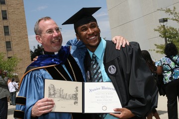 Photo of Xavier Graduate with Father Graham
