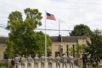 ROTC students standing in front of the American flag to give their respects