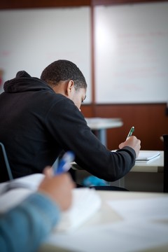 Student writing in a classroom