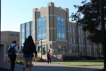 Students walking outside Alter Hall on a sunny fall morning.