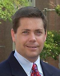 Portrait of Dr. Ed. Peck. He is wearing a suit and tie.