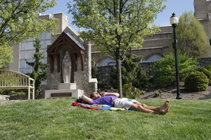 Photo of Student lying down next to Shrine of Our Lady