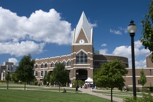 Exterior of Gallagher Student Center on a summer day. Trees line the paths leading to the building. 