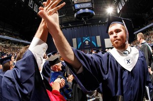 Xavier graduates celebrating inside Cintas during ceremony