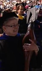 Photo of a Grand Marshal holding the Xavier University mace during an official ceremony