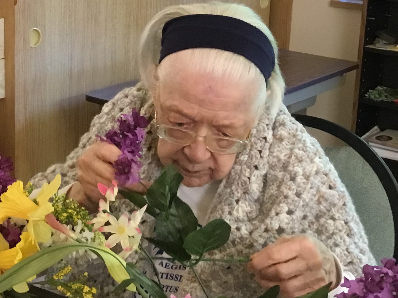 Photo of a Dementia patient admiring her gift of flowers