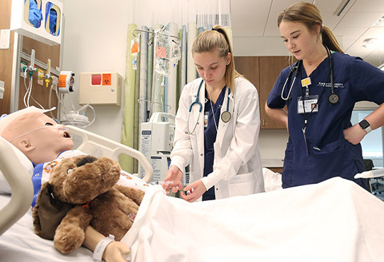 students in a nursing simulation laboratory learning to provide care