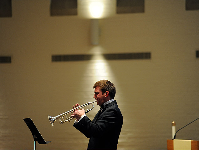 A music education major playing his instrument in front of a crowd 