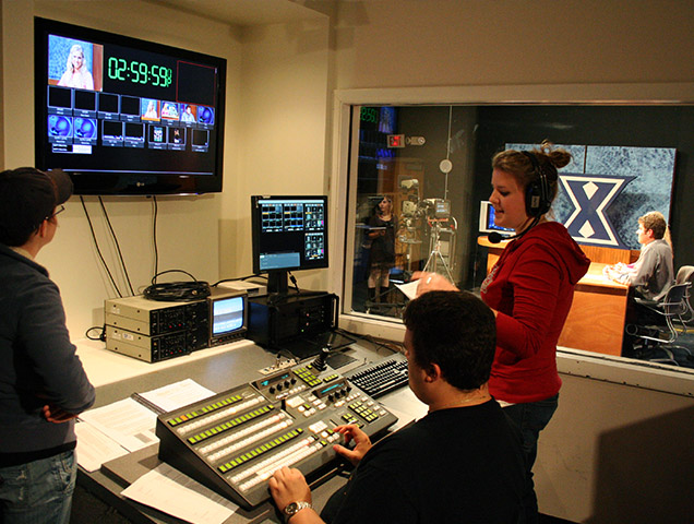 Students learning how to produce a television film in a studio room on campus