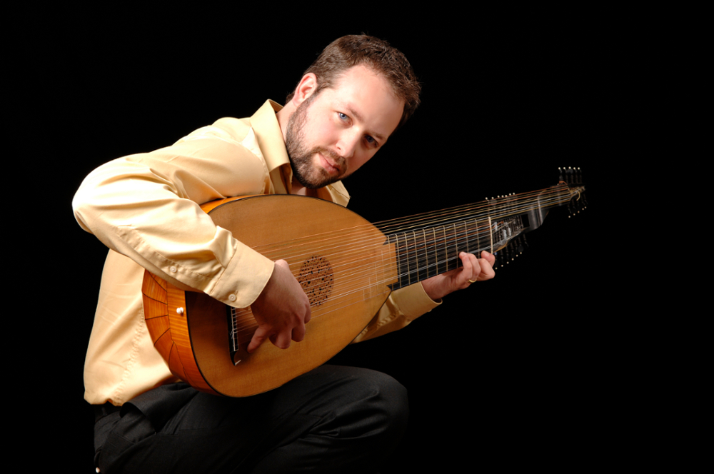 Photo of Chris Wilke holding a stringed instrument