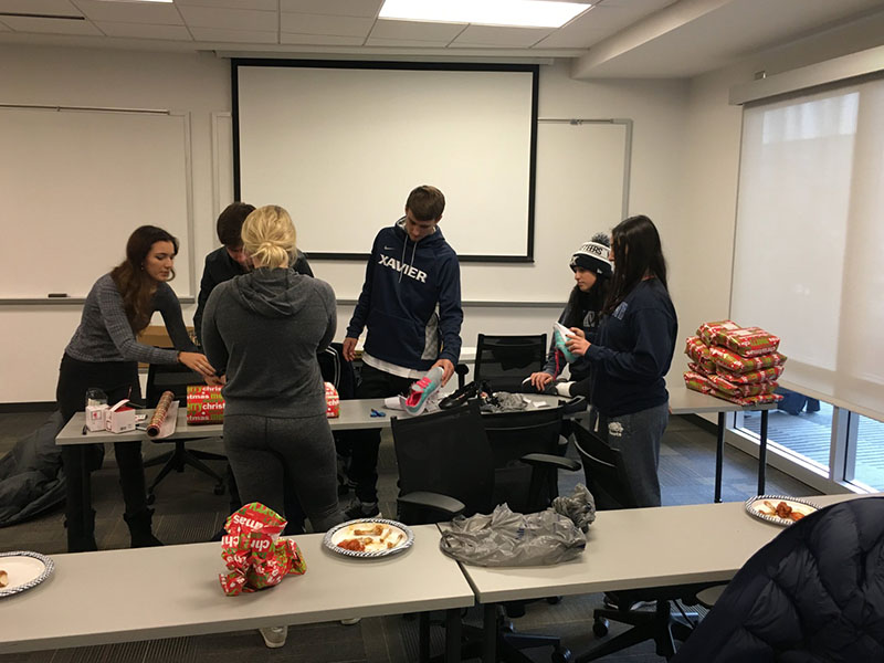 Xavier student athletes wrapping donated items