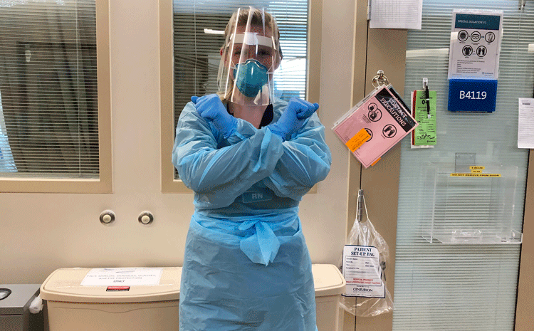 Photo of Allison Largent in her Nursing attire holding up an 'X' symbol with her arms