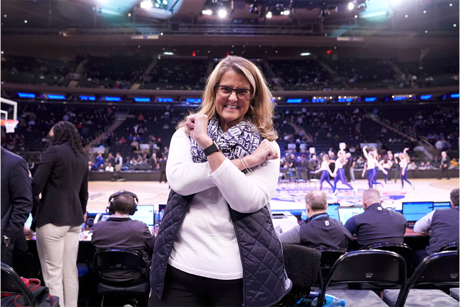Xavier University President Colleen Hanycz crosses her arms to form an X on the Cintas Center basketball court.