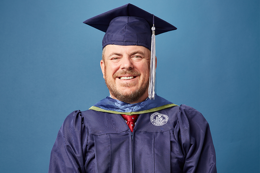 Michael Gigis poses for a portrait dressed in his cap and gown.