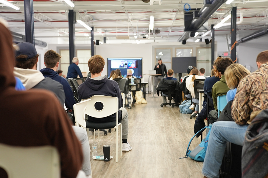 A room of nearly 70 people looks on as a Xavier student pitches their business idea.