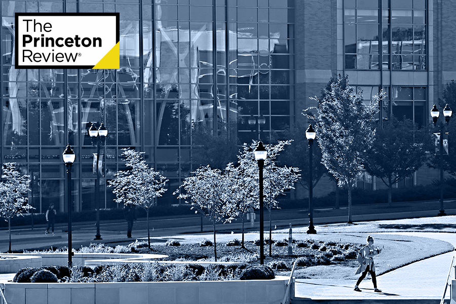 Photo of a student walking outside Smith Hall on Xavier's campus. There is a blue overlay over the photo. There is a yellow and white 'Princeton Review' logo in the top left corner.