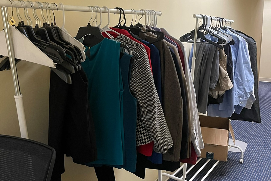 A clothing rack that has professinal coats, shirts and pants. 