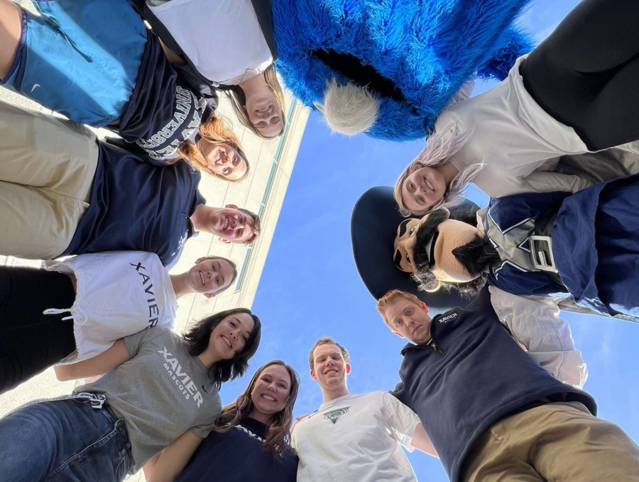 Xavier Mascot Team members stand in a circle with D'Artagnan and the Blue Blob.