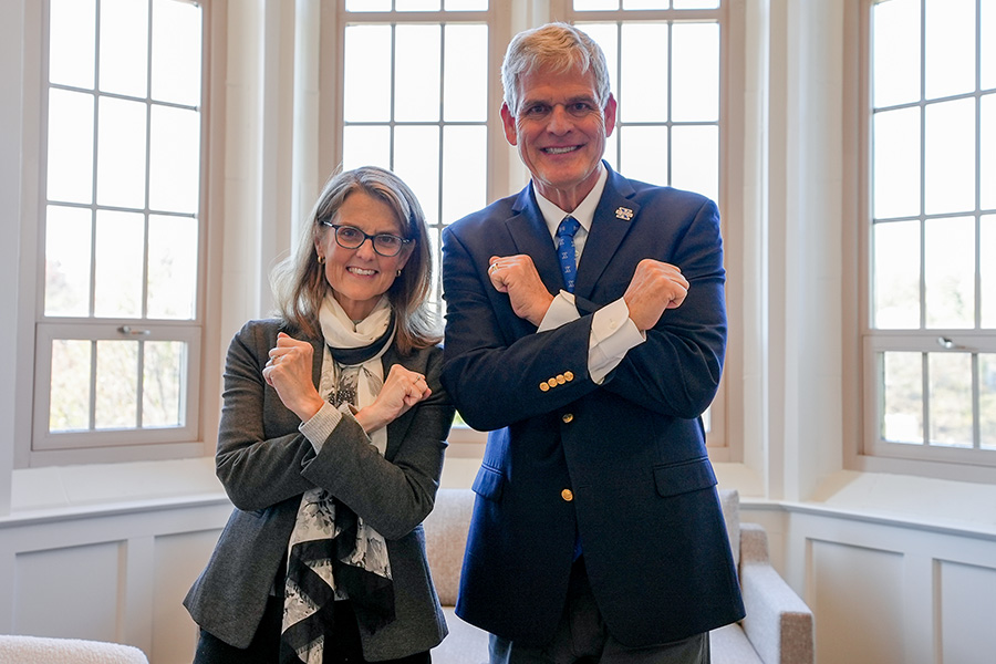 Xavier University President Dr. Colleen Hanycz and President of St. Xavier High School Tim Reilly put up their arms in the form of an X.