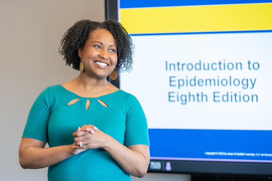 Health Services Administration professor Ashley White, PhD, leads a classroom through a powerpoint titled 'Introduction to Epidemiology, Eighth Edition'  